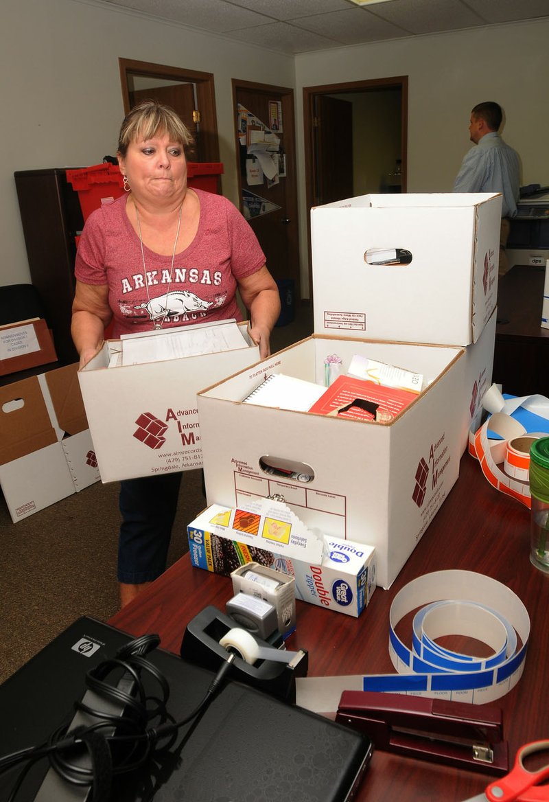 Lora Markham-Brown with the Benton County prosecutor’s office, stacks boxes Friday during the move from the Massey Building in Bentonville to the main courthouse.