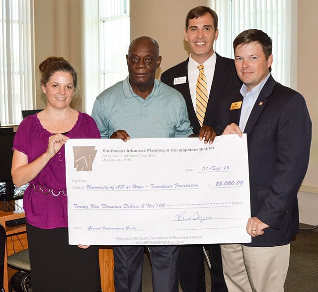 Renee Dycus (left), executive director of Southwest Arkansas Planning & Development District, Inc., along with State Rep. District 3 Brent Talley (right), present a check for $25,000 to Freddie Smith (left, center), chairman of the UofA Hope-Texarkana Board of Visitors and Chris Thomason (right, center), UofA Hope-Texarkana Chancellor. 