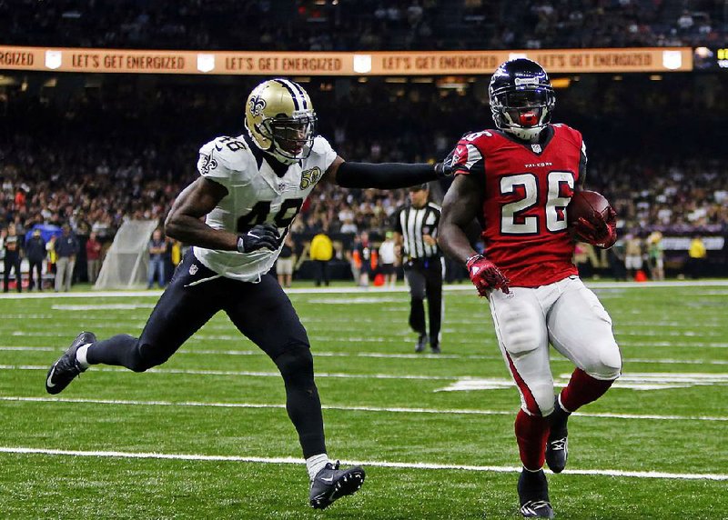 Atlanta running back Tevin Coleman (right) runs into the end zone for a touchdown in front of New Orleans safety Vonn Bell (left) in the second half of Monday’s night’s game. Coleman scored three touchdowns to help the Falcons pull away for a 45-32 victory and send the Saints to their third loss in a row.