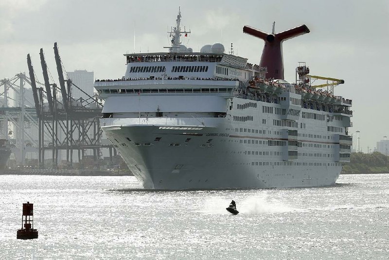 A jet skier passes in front of the Carnival Sensation cruise ship as it leaves Miami Beach, Fla., on June 20. The cruise operator on Monday announced a profit of $1.4 billion, or $1.93 a share, in the quarter that ended Aug. 31.