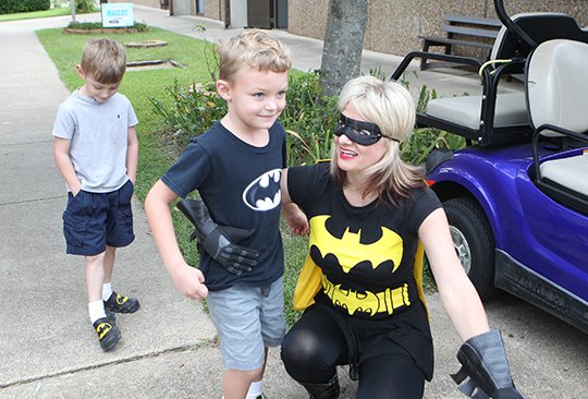 The Sentinel-Record/Richard Rasmussen SUPERHERO WELCOME: NPC employee Suzzanne Hendrix, dressed as Batgirl, greets Fountain Lake kindergarten students Jayden Wenzel, left, and Jace Wilie to campus Monday. About 80 kindergarten students from Fountain Lake took a tour of the college Monday.