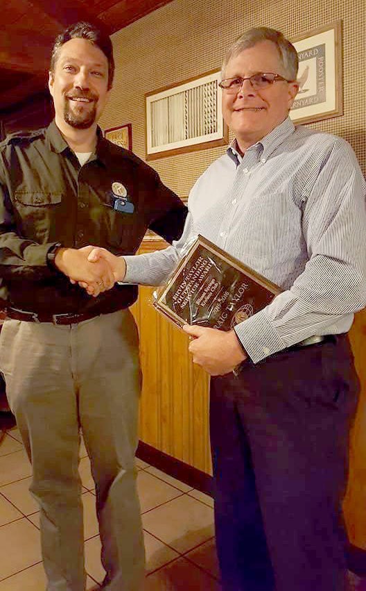 Photo submitted Siloam Springs Kiwanis Club outgoing president David Bailey, left, presented treasurer Craig Taylor the &quot;Erwin Taylor Outstanding Service Award&quot; that was named for his father.