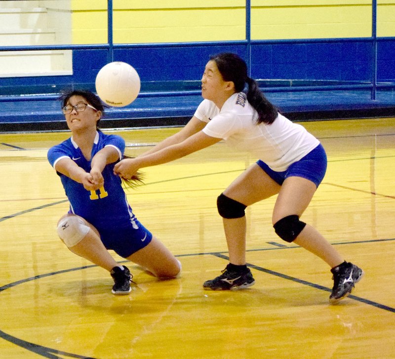 Photo by Mike Eckels Shaney Lee (Decatur 11) and Mailee Xiong intercept the ball at the same time during the Decatur-Elkins senior girls&#8217; volleyball conference match at Peterson Gym in Decatur Sept. 20.