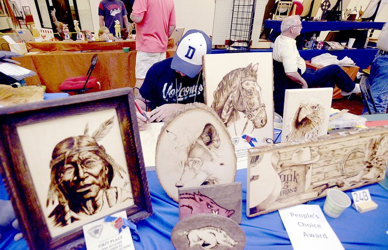 Ben Goff/NWA Democrat-Gazette Darin Keen of Bella Vista worked on a new pyrographic, or wood burning, piece at his table on Sept. 11 during the Woodcarvers of Northwest Arkansas annual show at Frisco Station Mall in Rogers. Keen said he&#8217;s been an artist his whole life, but just began wood burning three weeks ago. He won first place in the open division pyrographic with color and open division pyrographic without color categories at the show.