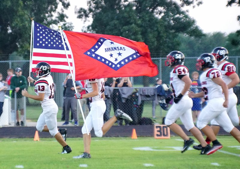 Photo by Randy Moll The Pea ridge team enter the field carrying the U.S. and Arkansas flags at the Gentry v. Pea Ridge football game in Gentry on Friday, Sept. 23, 2016.