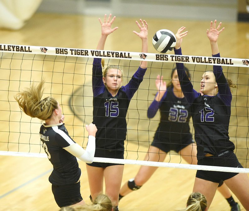 Ella May Powell (15) and Faith Waitsmaa (12) of Fayetteville go up for a block Tuesday against Bentonville in Bentonville.