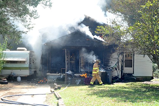 The Sentinel-Record/Mara Kuhn HEAVY SMOKE: Hot Springs firefighters work to extinguish a house fire in the 300 block of Crescent Street Tuesday afternoon. One firefighter was treated at National Park Medical Center and another firefighter was treated at the scene, both for heat exhaustion.