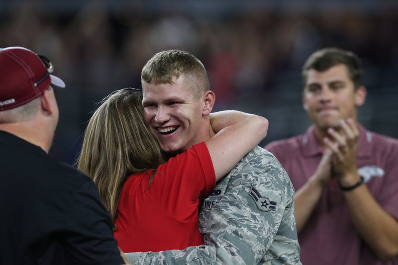 U.S. Air Force airman Channing Caudill hugs his mother, Mary Russell, after surprising her on the field at AT&T Stadium in Arlington, Texas, on Saturday, Sept. 24, 2016.