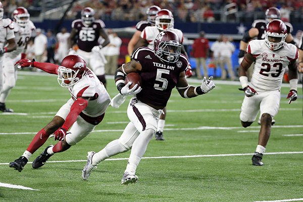 Arkansas defensive back Santos Ramirez, left, is unable to stop Texas A&M running back Trayveon Williams (5) as Williams sprints for the end zone and a touchdown late in the second half of an NCAA college football game, Saturday, Sept. 24, 2016, in Arlington, Texas. Texas A&M won 45-24. (AP Photo/Tony Gutierrez)

