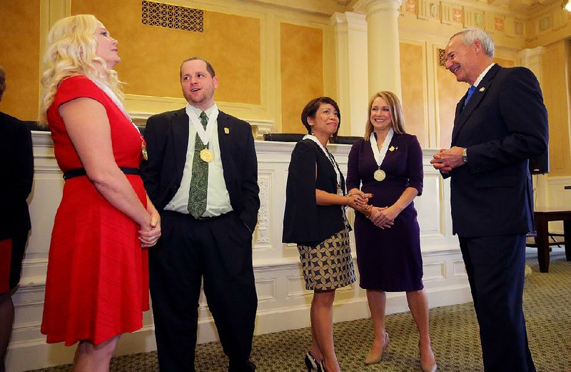 Arkansas Teacher of the Year finalists Julia Crane (from left), Brian Leonard, Emma Mateo and Courtney Cochran talk with each other and Gov. Asa Hutchinson (right) during a recognition event Wednesday at the state Capitol in Little Rock. 