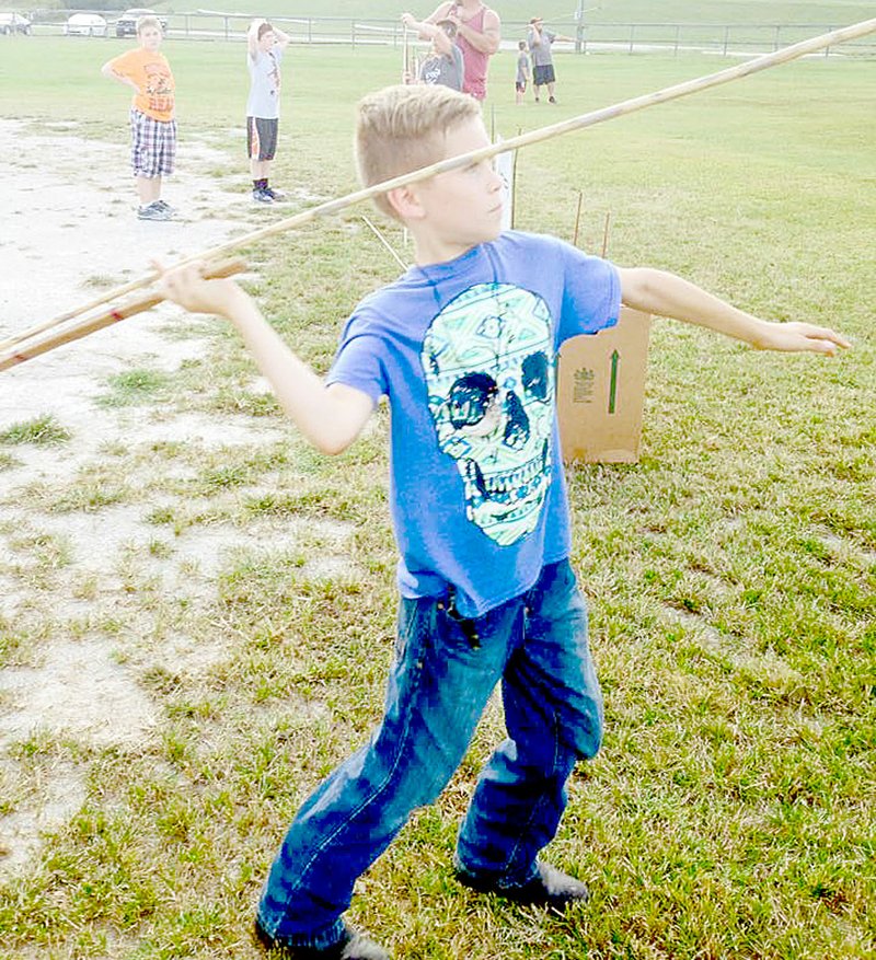PHOTO SUBMITTED Smooth Delivery &#x2013; Using an atlatl, Lewis Standingbear, 9, quickly had spears and darts flying thorugh the air at the Young Outdoorsmen United Primitive Hunting Tool Seminar for youth in Anderson.