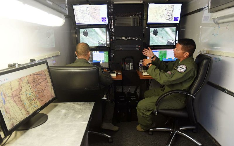 Members of the 188th Wing of the Arkansas Air National Guard use a simulator Thursday at their base in Fort Smith to demonstrate their remote-piloted role in combat missions. 