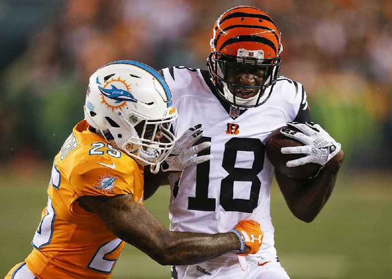 Cincinnati Bengals wide receiver A.J. Green (18) pushes past Miami Dolphins cornerback Xavien Howard (25) during the first half of Thursday’s game in Cincinnati. Green caught 10 passes for 173 yards and a touchdown in Cincinnati’s 22-7 victory.