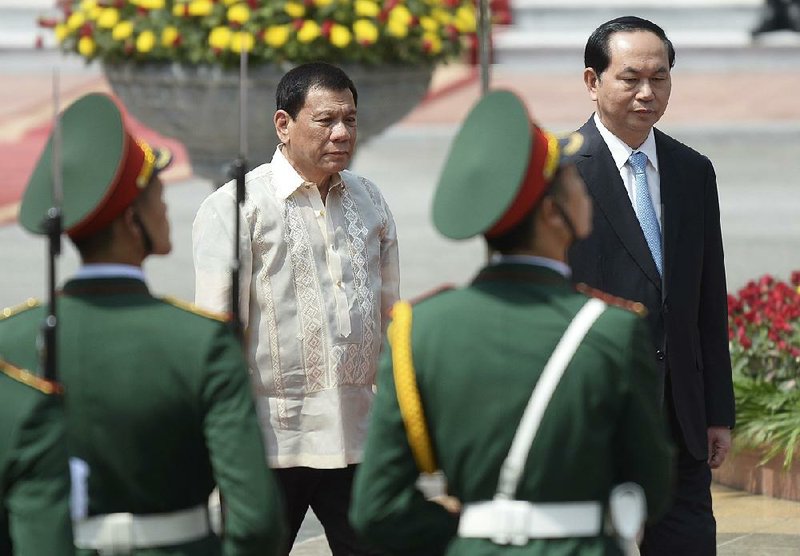 Philippine President Rodrigo Duterte (left) and Vietnamese President Tran Dai Quang review an honor guard Thursday during a welcoming ceremony for Duterte at the presidential palace in Hanoi, Vietnam. 
