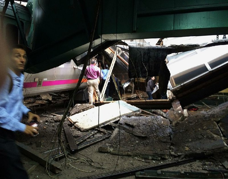 People look through the wreckage Thursday of the New Jersey Transit commuter train that ran off the end of the track and crashed about 8:45 a.m. at the station in Hoboken, N.J. 