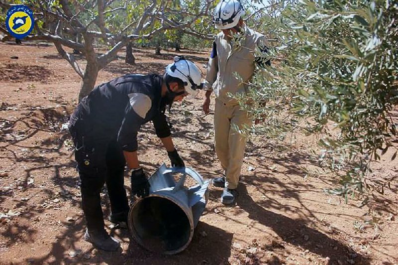 Members of the civil-defense group known as the White Helmets inspect cluster bombs Thursday in the Khan Sheikhoun neighborhood of Idlib, Syria. The White Helmets provided this photo.