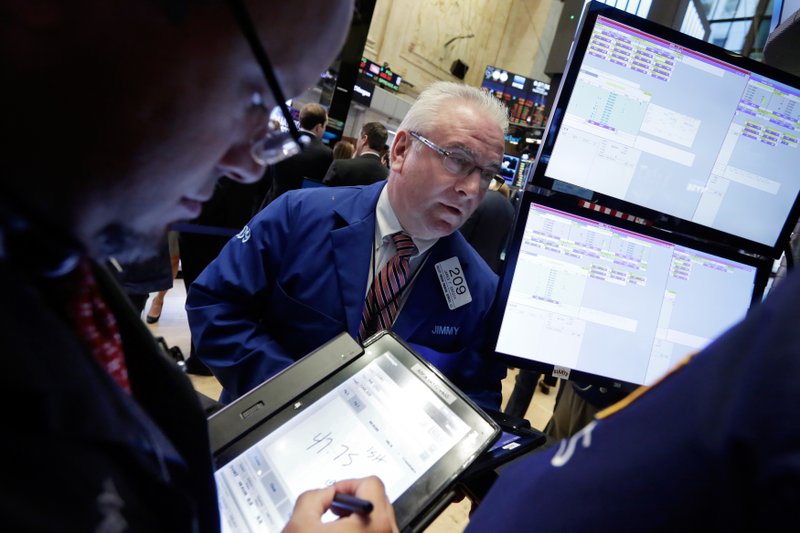 In this Monday, Sept. 26, 2016, file photo, trader James Dresch, center, works on the floor of the New York Stock Exchange. 