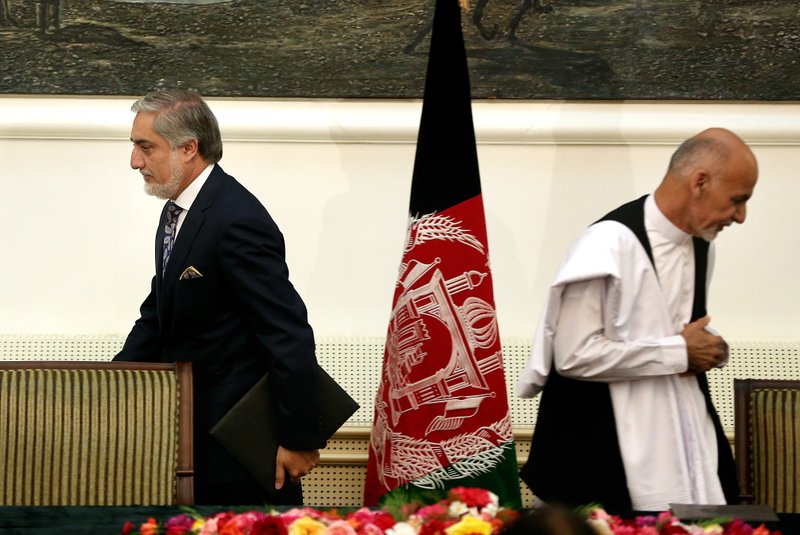 In this Sunday, Sept. 21, 2014 file photo, Afghanistan's then presidential election candidates Abdullah Abdullah, left, and Ashraf Ghani, right, leave after signing a power-sharing deal at presidential palace in Kabul, Afghanistan. 