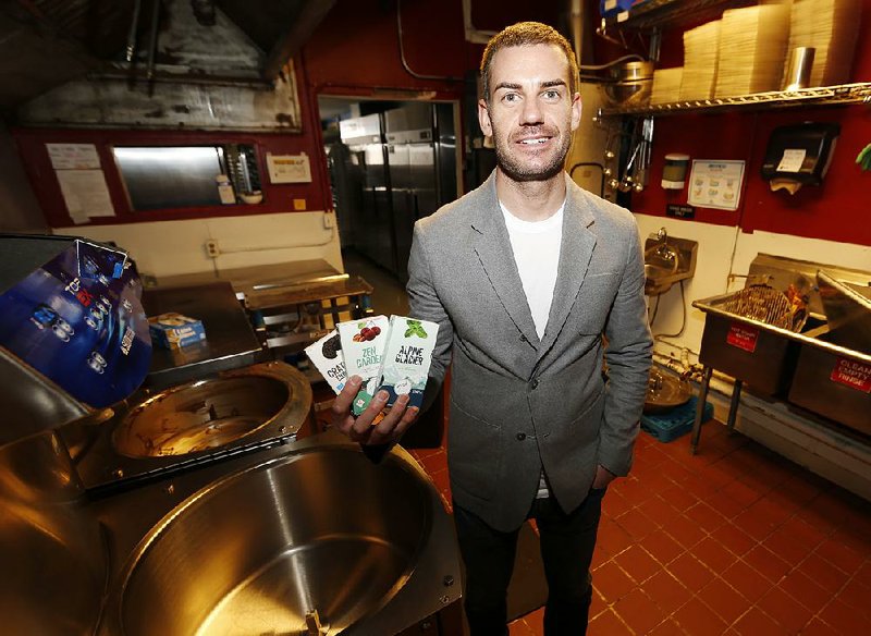 Andrew Schrot, chief executive officer of BlueKudu, shows some of the marijuana-infused chocolate bars made by the Denver company. Starting today, “pot”-infused foods in Colorado must be stamped with the label T-H-C.