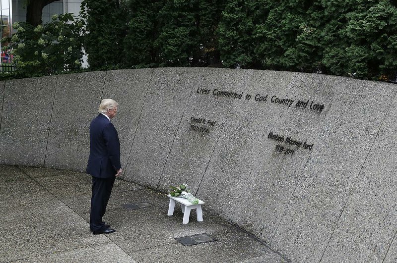 Republican presidential nominee Donald Trump stops at the grave of President Gerald Ford and his wife, Betty, during a visit Friday to the Gerald R. Ford Presidential Museum in Grand Rapids, Mich., as he campaigned in the state.