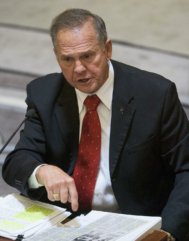 Alabama Supreme Court Chief Justice Roy Moore testifi es at his ethics trial Friday in Montgomery, saying he never set out to defy the U.S. Supreme Court.