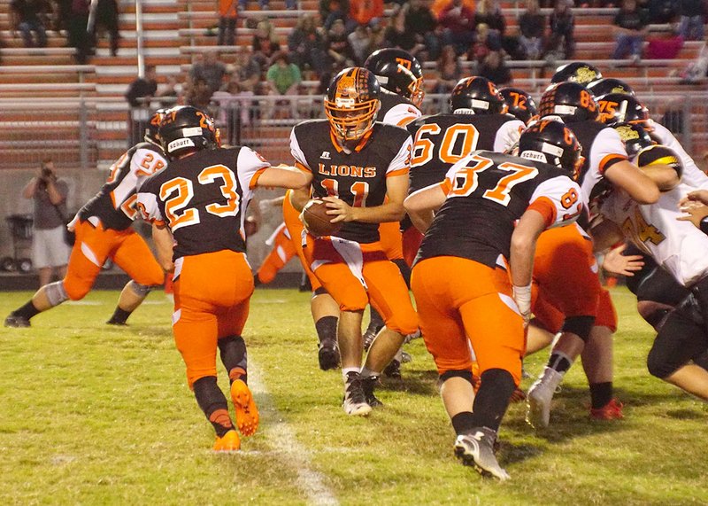 Gravette quarterback Kilby Roberts (11) hands off the ball to Brady Moorman (23) on Friday at Lion Stadium in Gravette.