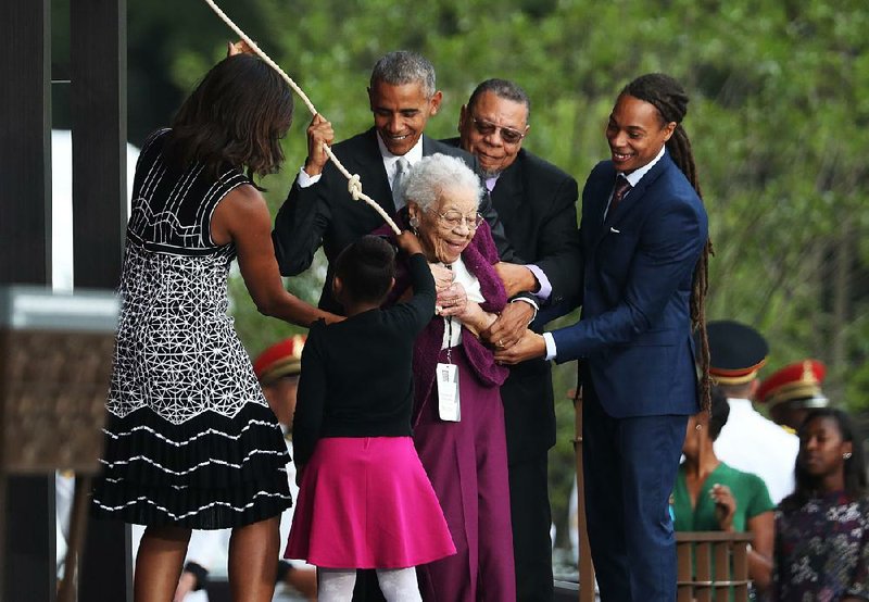Ruth Odom Bonner, with the help of the Obamas and others, rings the bell opening the National Museum of African American History and Culture. 