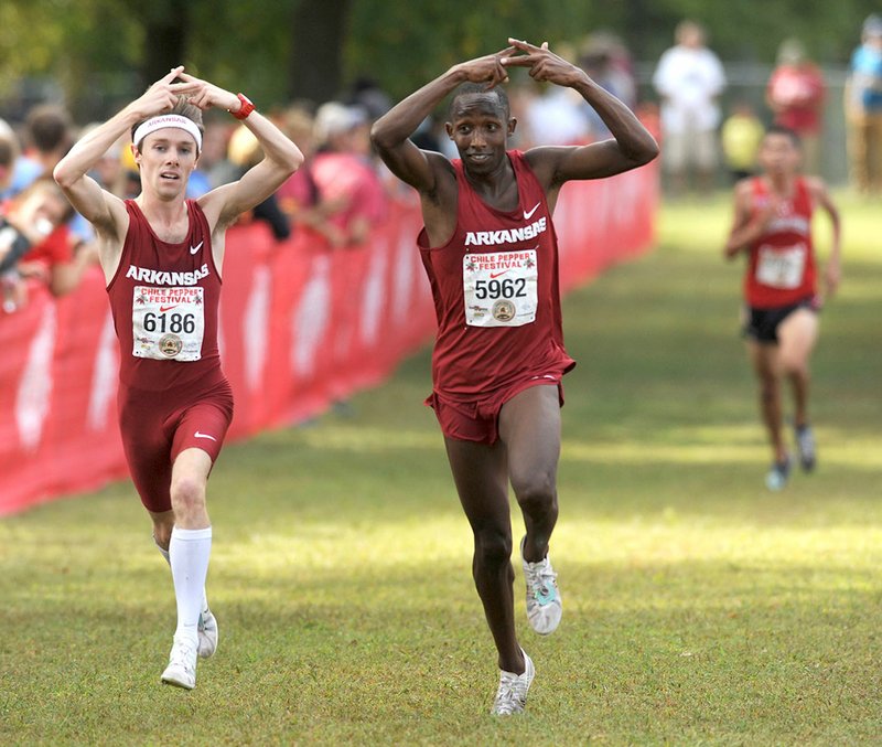 Arkansas’ Alex George (left) and Frankline Tonui create an “A” gesture Saturday as they approach the finish line in Fayetteville.