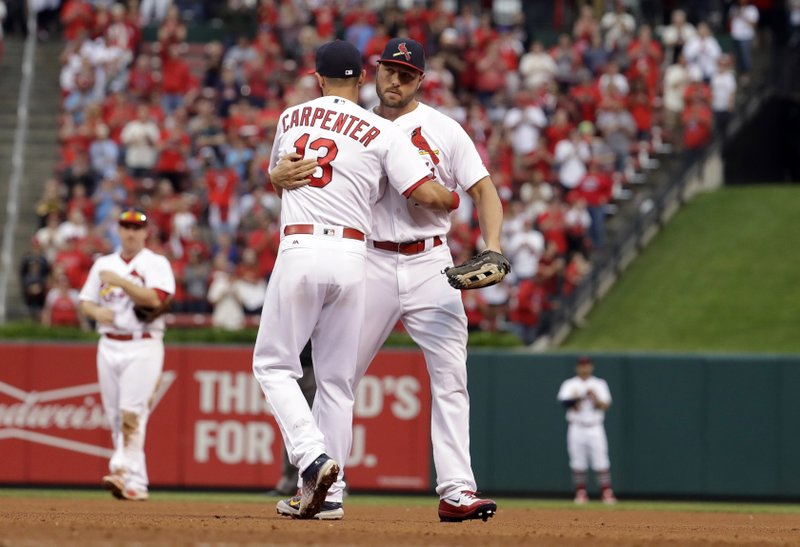 St. Louis outfielder Matt Holliday (right) gets a hug from teammate Matt Carpenter after leaving Sunday’s game in the ninth inning. Holliday, who played for two pitches, will not return to the Cardinals after the club said they are refusing to pick up his option.