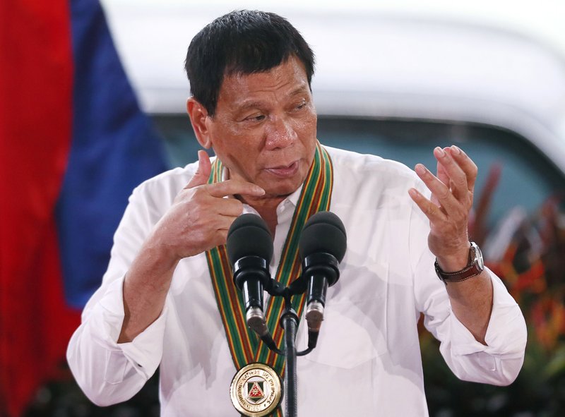 Philippine President Rodrigo Duterte gestures with a firing stance as he announces issuing side arms to army troopers during his visit to its headquarters in suburban Taguig city east of Manila, Philippines Tuesday Oct. 4, 2016. U.S. and Philippine forces opened their first large scale combat exercises under President Duterte in uncertainty Tuesday after he said the drills will be the last in his six-year presidency partly to avoid upsetting China.(AP Photo/Bullit Marquez)
