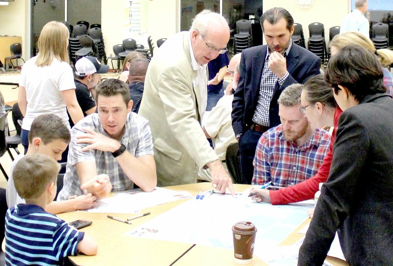 Keith Bryant/The Weekly Vista Mayor Peter Christie, center left, and Tony Garcia of Street Plans Collaborative, center right, discuss the temporary trail at Wednesday&#8217;s public input meeting.