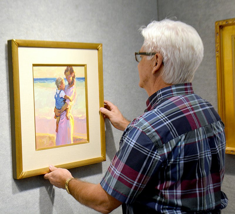 Janelle Jessen/Herald-Leader Charles Peer, John Brown University art gallery director, hung a painting owned by artist Dede Hutcheson in preparation for the exhibit, &quot;The Hutcheson Collection: From the Eye of an Artist.&quot; The opening reception for the exhibit, which is free and open to the public, will be held from 7 to 8:30 p.m. Thursday in the Windgate Visual Arts Gallery West.