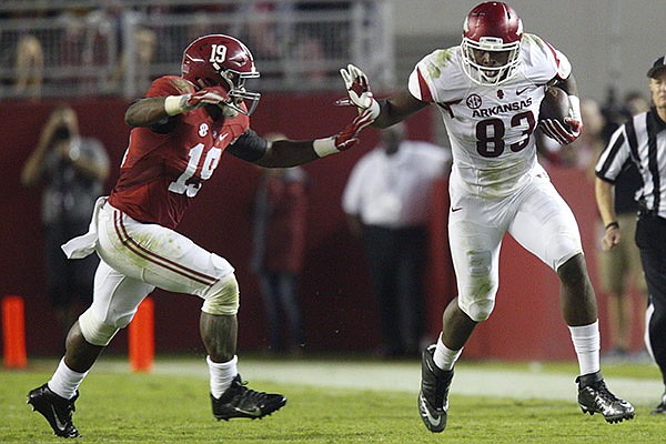 Arkansas tight end Jeremy Sprinkle (83) pushes off a tackle attempt from Alabama linebacker Reggie Ragland (19) during the third quarter on Saturday, Oct. 10, 2015, at Bryant-Denny Stadium in Tuscaloosa, Ala.
