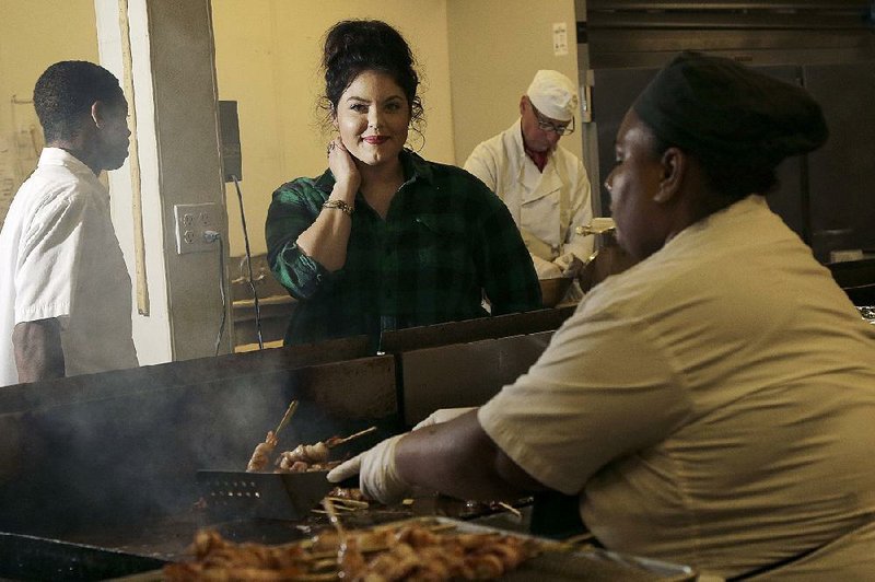 Olivia Colt, owner of catering company Salt & Honey (center), watches as members of her cooking staff work in the kitchen in Berkeley, Calif. Colt’s hourly employees accrue an hour of sick leave for each 30 hours they work. 