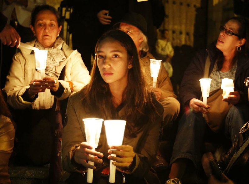 Colombians share candles during a march Wednesday night in Bogota to demand that the government and leftist rebels continue to seek a peace agreement after Sunday’s rejection at the ballot box of an accord already signed by both sides. Thousands joined the march that was organized on social media by student groups and social movements.