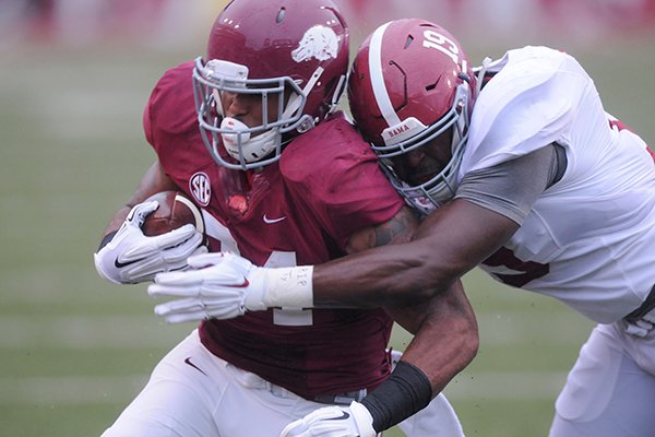 Arkansas running back Kody Walker is tackled by Alabama linebacker Reggie Ragland during a game Saturday, Oct. 11, 2014, in Fayetteville. The Crimson Tide won its last game at Arkansas by a final score of 14-13.