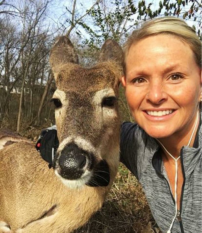 Sarah Losh poses with Doug the Deer on Dogwood Springs Trail in Siloam Springs. Losh said she thought the friendly deer “was fi ne in his area” and was not a danger to people “at all.”