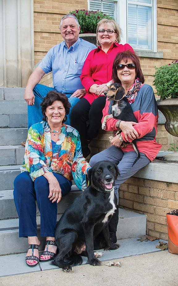 Faulkner County Judge Jim Baker, clockwise from top left, sits in front of the courthouse in Conway with Faulkner County Animal Shelter Advisory Board members Donna Clawson, Chris Quinn, holding Lady D, and Vickie Crutchfield with Captain Hook. The Faulkner County Quorum Court released $30,000 from a $1.1 million animal-shelter account to get started on the project. Clawson said if people would pay their voluntary taxes for animal welfare, the shelter could be built sooner.