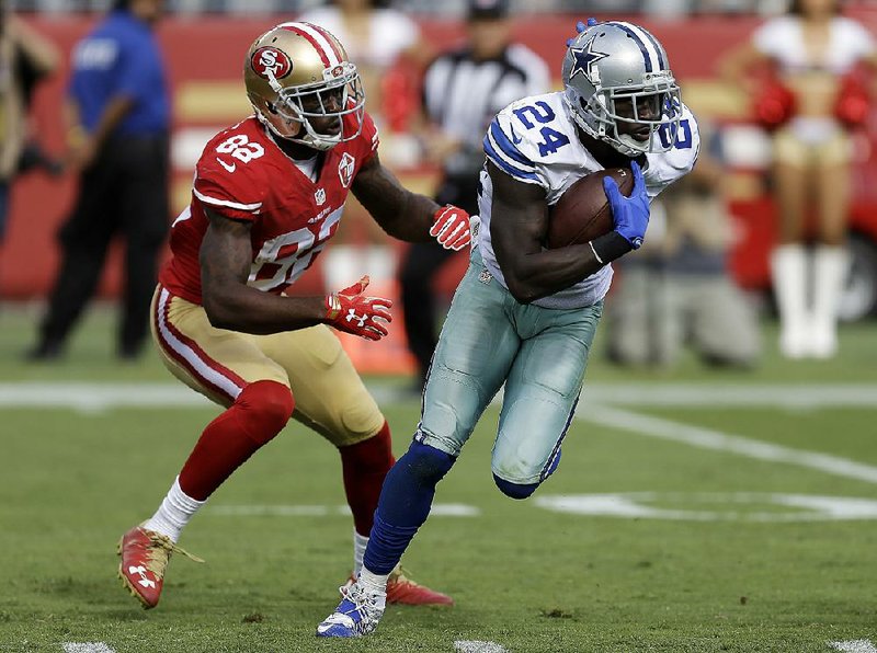 Dallas Cowboys cornerback Morris Claiborne (right) returns an interception in front of San Francisco 49ers wide receiver Torrey Smith during the second half of Sunday’s game in Santa Clara, Calif. It was Claiborne’s first interception in more than two years. 