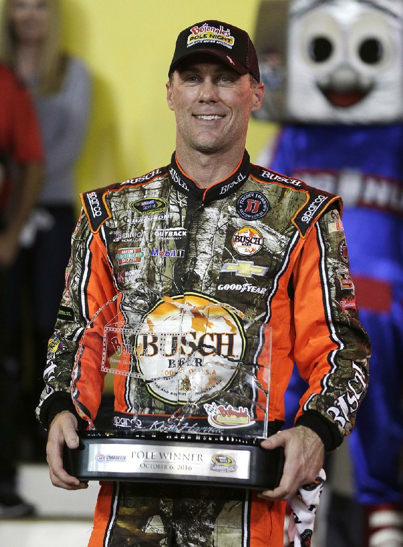 Kevin Harvick poses with the trophy after winning the pole for Saturday's NASCAR Sprint Cup series auto race at Charlotte Motor Speedway in Charlotte, N.C., Thursday, Oct. 6, 2016. 