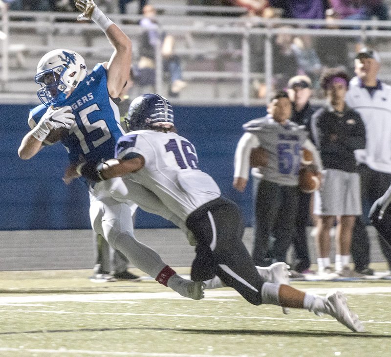 Will Litzinger (31) of Fayetteville attempts to tackle Jeb Brain (7) of Rogers on Friday at Whitey Smith Stadium in Rogers.