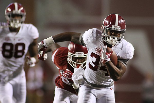 Alabama's Damien Harris runs away from an Arkansas defender during the second quarter of an NCAA college football game Saturday, Oct. 8, 2016, in Fayetteville, Ark. (AP Photo/Samantha Baker)

