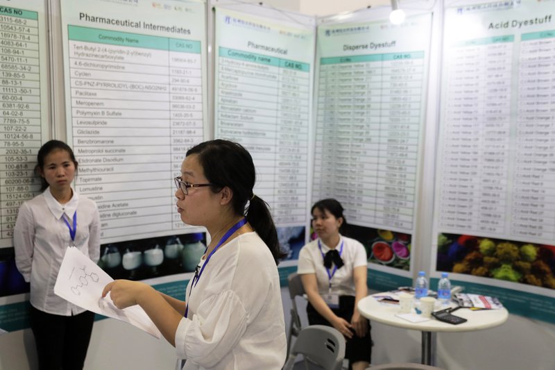 Xu Liqun (center), president of Hangzhou Reward Technology, speaks Sept. 21 at the company’s booth during the China International Chemical Industry Fair in Shanghai, China. Liqun said her company could produce carfentanil to order. 
