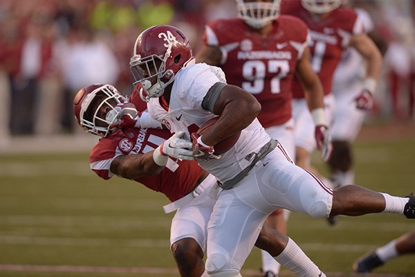 Alabama running back Damien Harris (34) stiff-arms Arkansas defensive back Ryan Pulley (11) during a game Saturday, Oct. 8, 2016, in Fayetteville. 