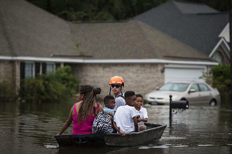 A Pooler, Ga., firefighter moves people out of their flooded homes Saturday after heavy rain from Hurricane Matthew swamped the suburb of Savannah, Ga. 