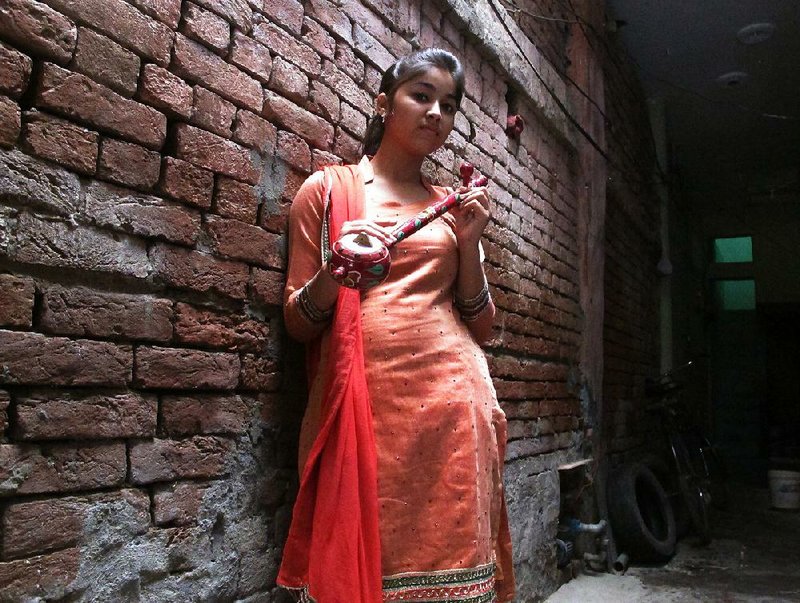 Ginnia Mahi, who proudly proclaims her caste, holds a Punjabi folk instrument called a thumbi at her home in Jalandhar. 