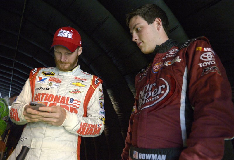 In this July 5, 2014, file photo, Alex Bowman, right, watches as Dale Earnhardt Jr. sends out a tweet, while waiting under a tunnel for driver introductions to begin, before a NASCAR Sprint Cup Series auto race at the Daytona International Speedway in Daytona Beach, Fla. Bowman will start a career-best 2nd at rain-soaked Charlotte Motor Speedway. Hurricane Matthew pushed the race from Saturday night until Sunday, but Bowman is eagerly awaiting his chance to prove himself while driving as the substitute for Earnhardt. 