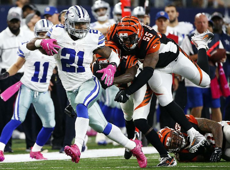 Dallas running back Ezekiel Elliott (left) runs past Cincinnati defenders in the second half of Sunday’s game at AT&T Stadium in Arlington, Texas. Elliott fi nished with 134 yards rushing to help the Cowboys beat the Bengals 28-14.
