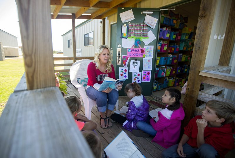 Nona Rogers reads to her fourth-grade class Friday on the porch of their classroom at Centerton Gamble Elementary School.
