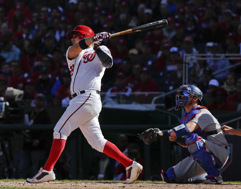 Washington Nationals' Jose Lobaton, left, connects for a three-run home run off Los Angeles Dodgers starting pitcher Rich Hill during the fourth inning in Game 2 of baseball's National League Division Series at Nationals Park, Sunday, Oct. 9, 2016, in Washington. Dodgers catcher Yasmani Grandal, right, looks on. 